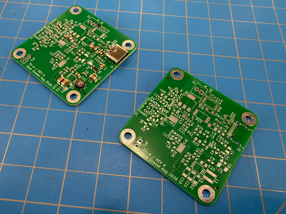 Partially assembled TX-A transmitter beside an unpopulated transmitter PCB.